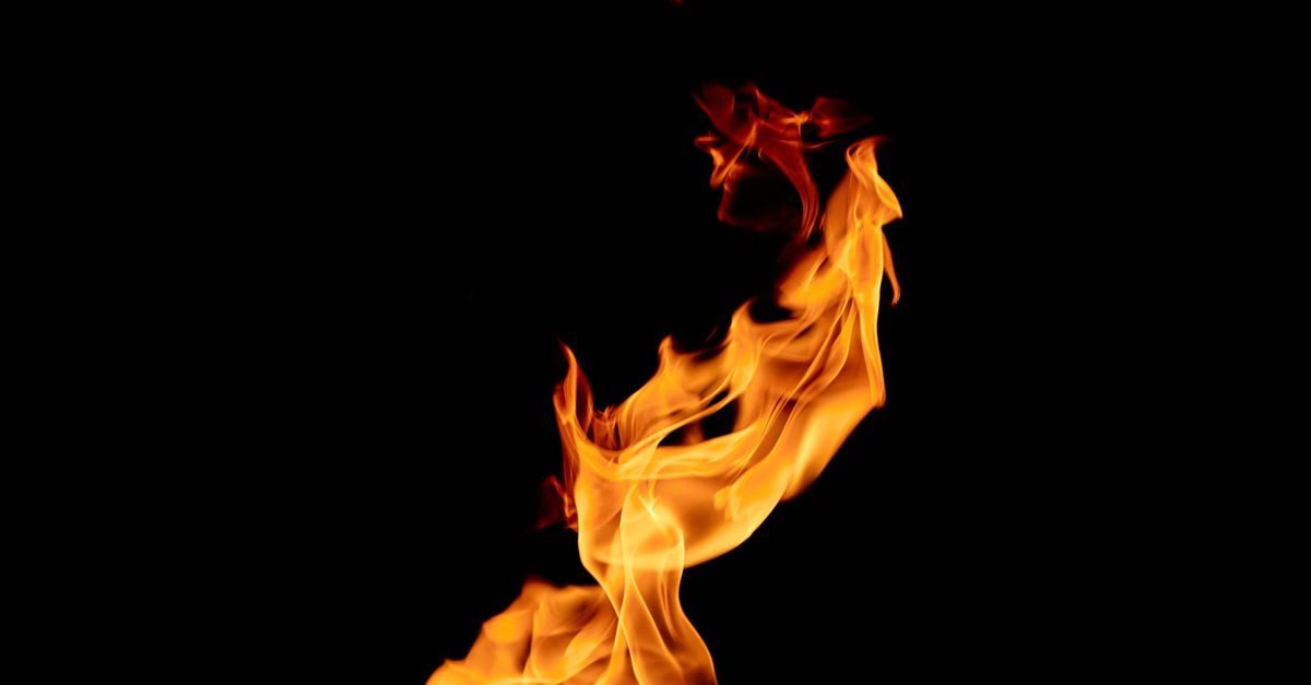 Vivid flames dance intensely against a stark black backdrop, showcasing the beauty of fire.